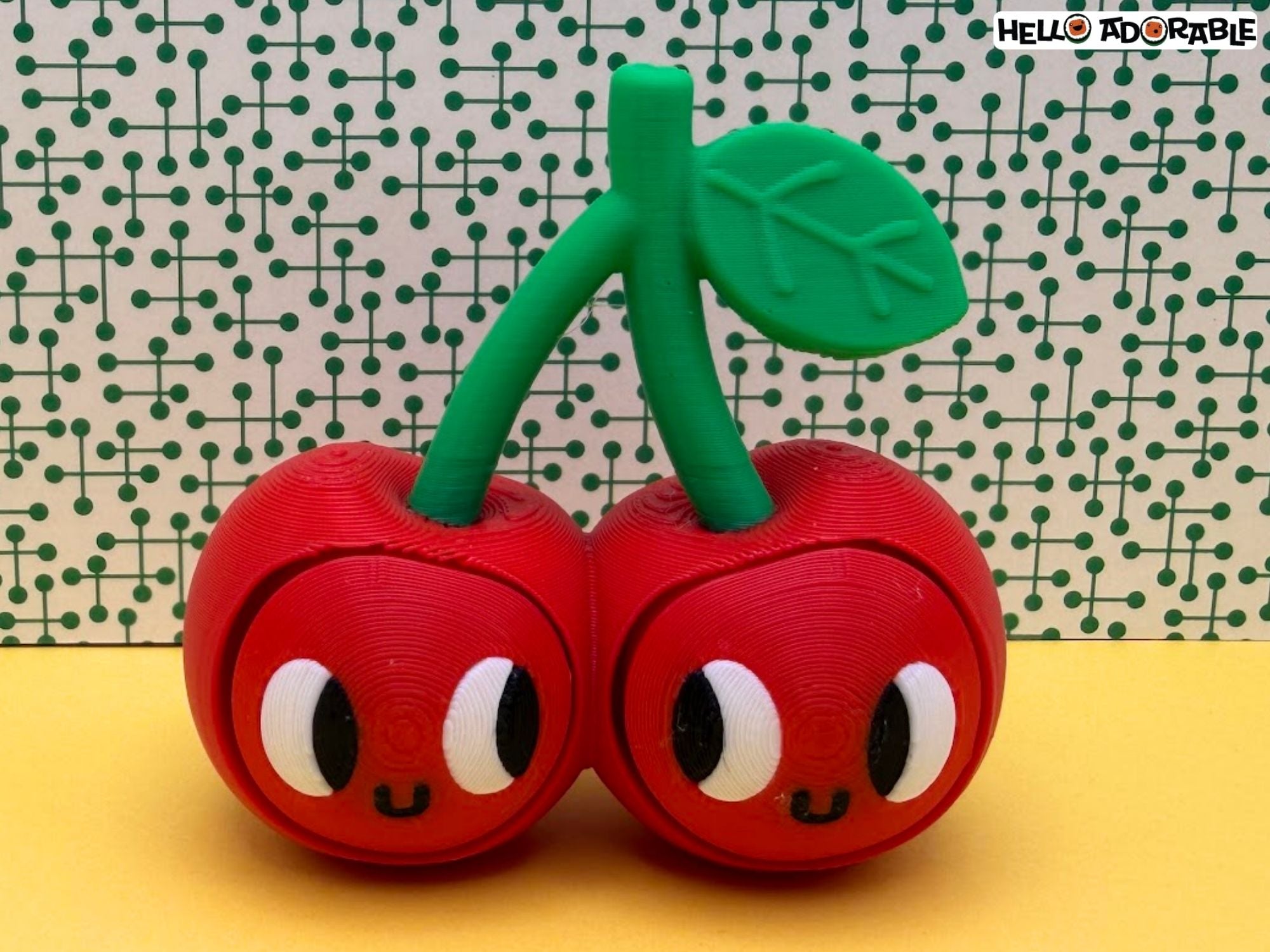 3D printed cherry fidget clicker with smiling faces